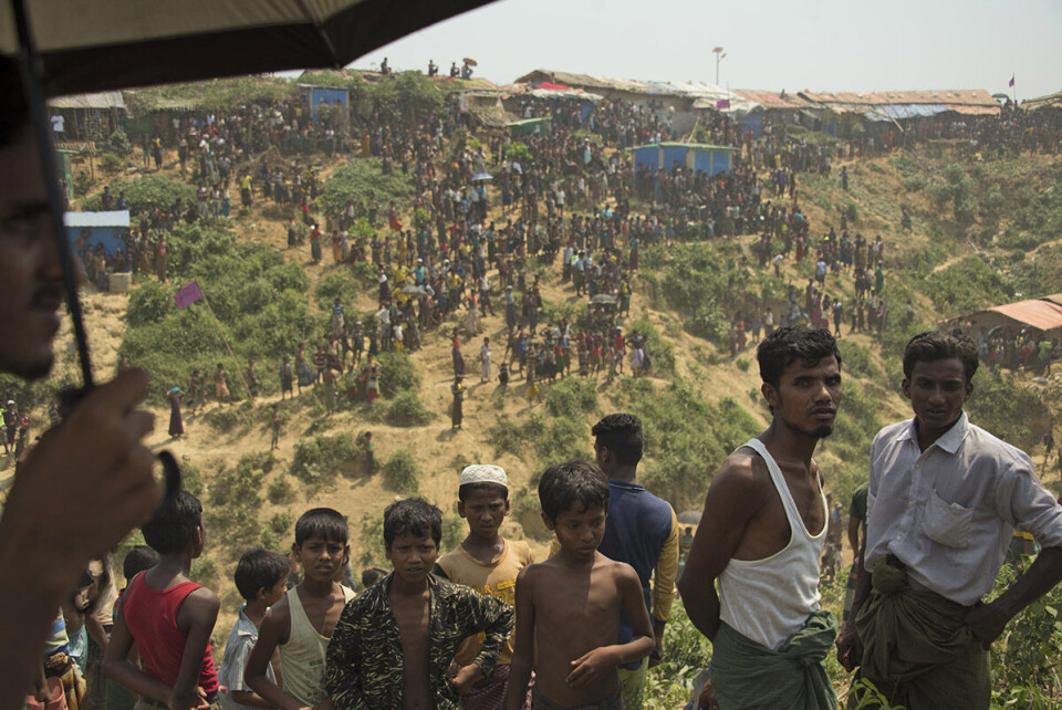 Rohingya-flyktninger ser på mens brannmannskap slukker en brann i en av flyktningleirene nær Cox's Bazar i Bangladesh. Brannen ødela over 20 hytter og en moské onsdag. Foto: AP / NTB scanpix