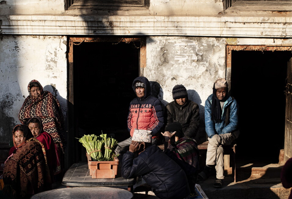 ÅRENE ETTER SKJELVET: Innbyggere i Khokana i Nepal sitter i solveggen utenfor huset sitt. Mer enn 600 000 hus ble ødelagt av flere store jordskjelv i landet i april 2015.